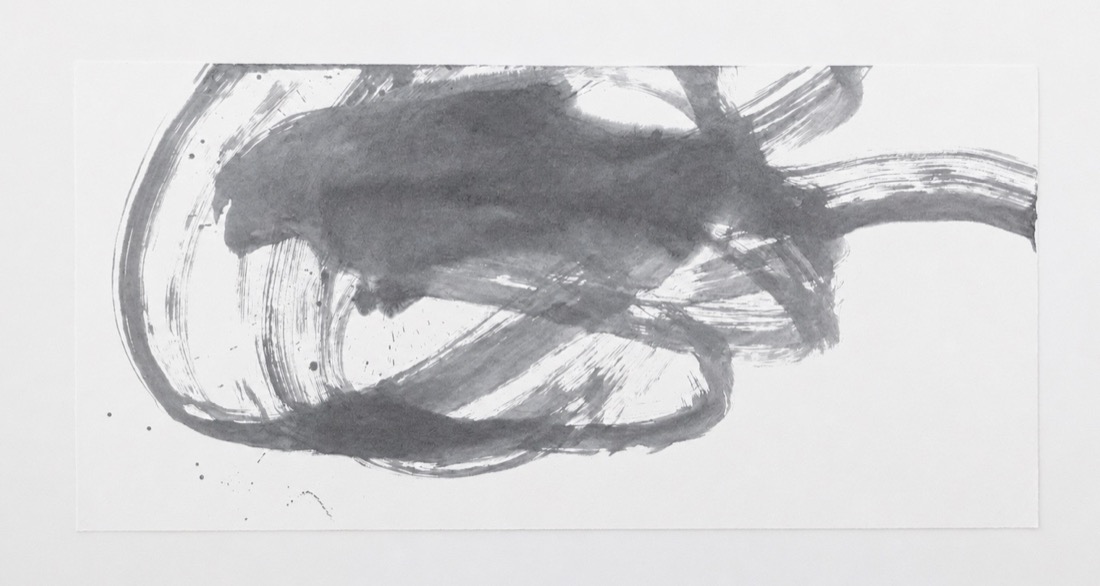 横長の紙に、力強い横の払いで描かれたノールック書道の墨作品