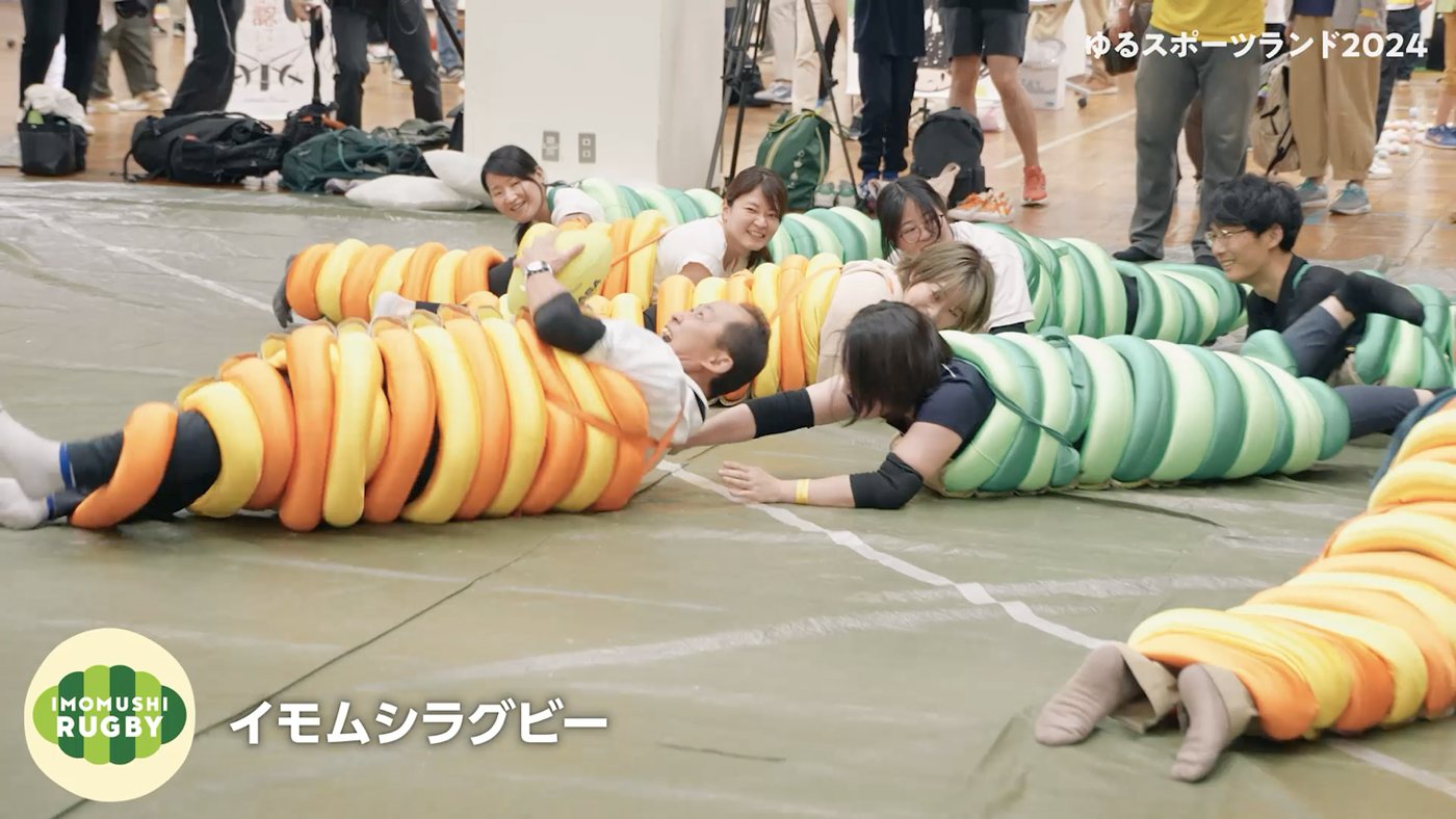 芋虫型のウェアを着て這って進むイモムシラグビーの競技風景