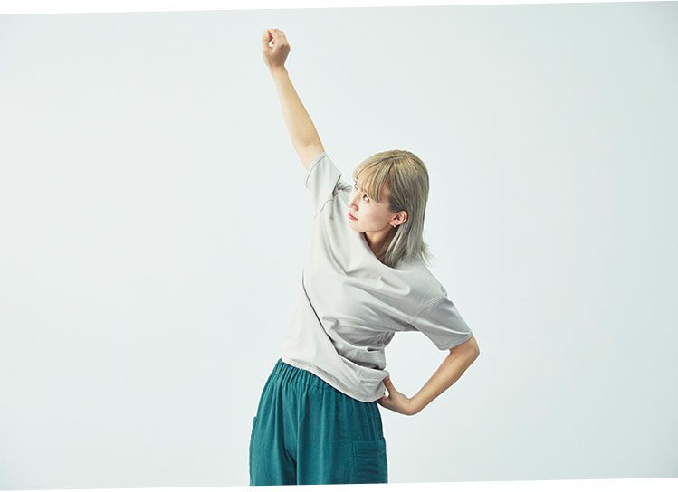 裏表のない服を着て、拳を高く突き上げるモデル