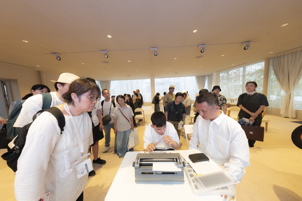 点字タイプライターに向かい、その場で手紙を綴るライブ点字タイピングの実演